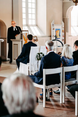 Brautpaar mit Familie und Gästen in der Kirche