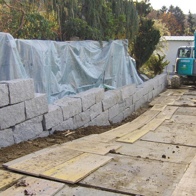Eberhard Gartenbau AG Kloten , Während dem Bau einer Granitsteinmauer mit Blocksteinen, auf dem nächsten Foto ist die gesamte Mauer ersichtlich.