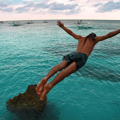 My friend Tom is flying high. Cliff Diving from the rocks between White Beach and Diniwid Beach. Boracay, Philippines. 2013 © Sabrina Iovino | JustOneWayTicket.com