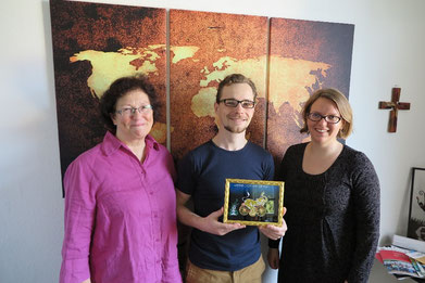 Marion Reichow (von links), Alexander Sichwardt und Tabea Kölbel mit dem Glasbild mit einem radelnden Elefanten als Dankeschön für die vorbildliche Zusammenarbeit