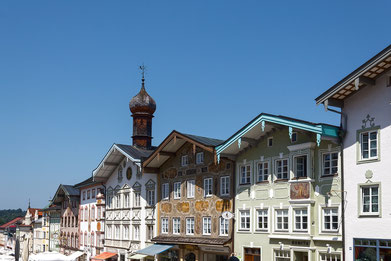 bunt verzierte Häuserreihe mit markanten Dachüberständen in der Marktstraße von Bad Tölz