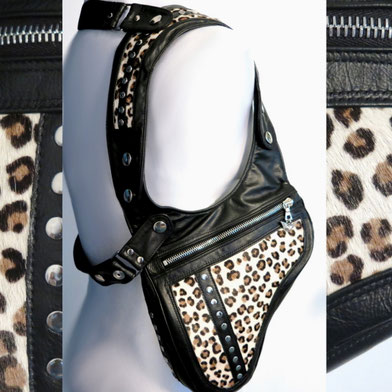 weisse Schneiderpuppe mit einem Revolverbag aus schwarzem Leder und Animalprint