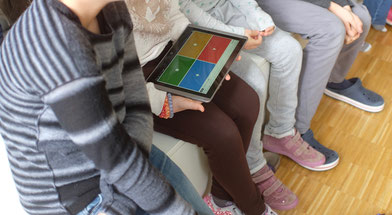 Schüler/-innen mit einem Tablet