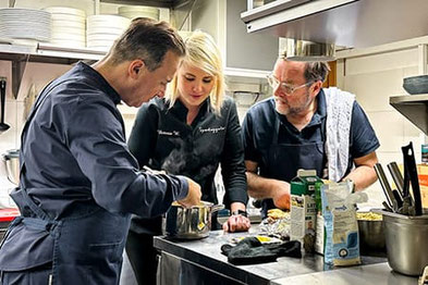 Victoria vom Speckeggele kocht zusammen mit Tim Raue und Sepp Schellhorn in der Restaurantküche in Schlanders – konzentrierte Küchenarbeit beim Kitchen-Impossible-Dreh.