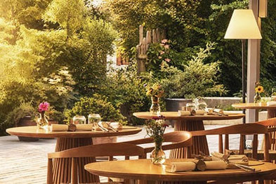 LA VIMEA Vegan Restaurant in Naturns: Stilvolle Terrasse mit Blick ins Grüne, liebevoll gedeckten Tischen und entspannter Atmosphäre für veganen Gourmetgenuss.