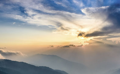 Ein leicht wolkiger Himmel verdeckt gerade so die Sonne, die totzdem mit ihren Strahlen das Bild durchdringt. Es steht hier für das Element Luft in der hawaiianischen Massage und Körperarbeit Lomi Lomi.