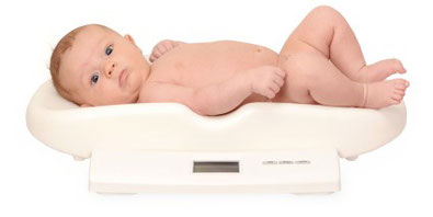 Ein Baby liegt auf einer Waage.