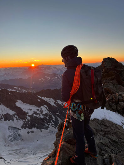 Bergführer geniesst den Sonnenaufgang auf dem Gipfel