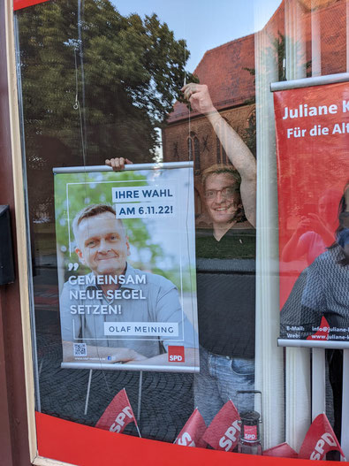 Robert Drews hängt das erste Wahlplakat von Olaf Meining auf