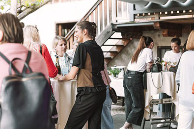Gäste bei einem Tapas- und Musikabend im Stadele Lana – entspannte Atmosphäre, Stehtische, Gespräche und Drinks im Innenhof.