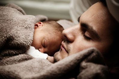 entspannter Vater mit schlafendem Baby