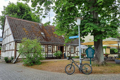 An einer Kreuzung steht ein altes Fachwerkhaus. Ein Schild zeigt einen Traßennamen: Fontanestraße steht darauf.