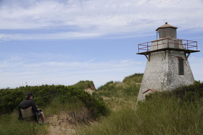 Painting the New London Lighthouse Prince Edward Island. The lighthouse is slowly being walled in by the dunes. 