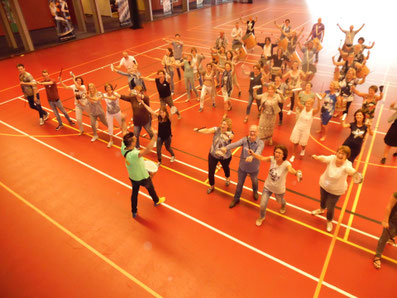 Groep collega's in Eindhoven tijdens een energieke trommel workshop op authentieke Braziliaanse instrumenten.
