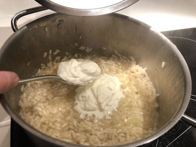 Den steif geschlagenen Rahm unter den Risotto ziehen