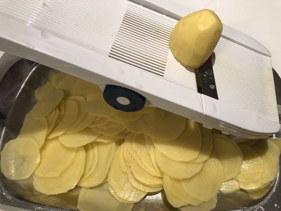 Die Kartoffeln mit der Mandoline raffeln