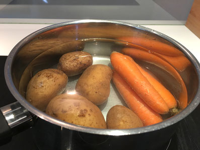 Kartoffeln und Karotten in Salzwasser blanchieren