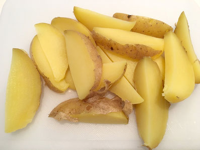 Kartoffeln in der Schale gar kochen und vierteln