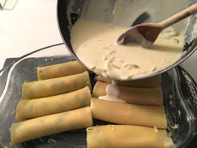 Die Cannelloni mit der Sauce übergießen