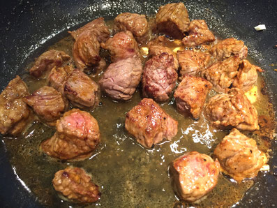 Die Fleischwürfel in Sonnenblumenöl mit Knoblauch und Curry kurz anbraten und mit Weissein ablöschen