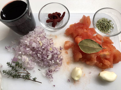 Zutaten zur Fleischmasse: Zwiebel, Knoblauchzehen, Tomatenmark, Tomaten, Thymian, Oregano, Lorbeerblatt, Rotwein, Salz, Pfeffer