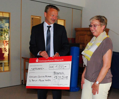 KSK-Regionaldirektor Matthias Reichelt überreicht Büchereileiterin Ingrid Reis einen Scheck in Höhe von 1000 Euro.
