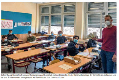 Lehrer Georg Kohlschmitt von der Donaueschinger Realschule mit der Klasse 8e. In der Hand hält er einige der Schnelltests, mit denen Lehrer und Schüler vor Ort zuvor getestet werden müssen.