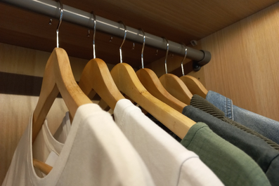 Kleiderbügel mit Bekleidung im Kleiderschrank