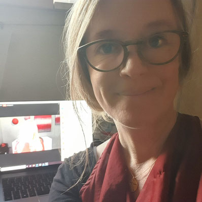 Sina Emrich sitzt vor ihrem Laptop und macht ein Selfie