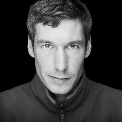 Professionelles schwarzweißes Mitarbeiterportrait mit natürlichem Blick und schwarzem Hintergrund – Business Portrait von Sebastian Bisch Fotografie