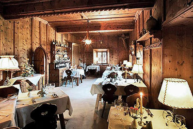 Gemütliche Stube im Restaurant Ansitz Kematen mit holzvertäfelten Wänden, gedeckten Tischen, Kerzenlicht und traditioneller Atmosphäre im historischen Ambiente.