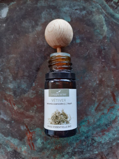 Picture of wooden ball diffuser in a bottle of Vetiver oil