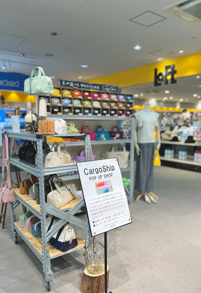 高松発の帆布バッグのお店、Cargo Shipが2026.5.1~5.10まで、期間限定でPOPUP SHOPを開催。普段使いしやすいカラーの帆布バッグが並び、奥のマネキンは手に黄色い横長ボストンバッグを持っています。