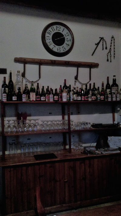 Bar with old bottley of liquor, glasses, red wine, white wine, whiskey, cognac, sherry, a chair in the front. South Africa.
