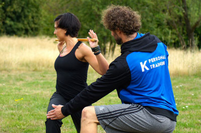 Personal Trainer und Schmerztherapeut Patrick Kuetemeier korrigiert Uebungsausfuehrung einer Klientin beim Fitness Training zur Verbesserung der Beweglichkeit und Kraft