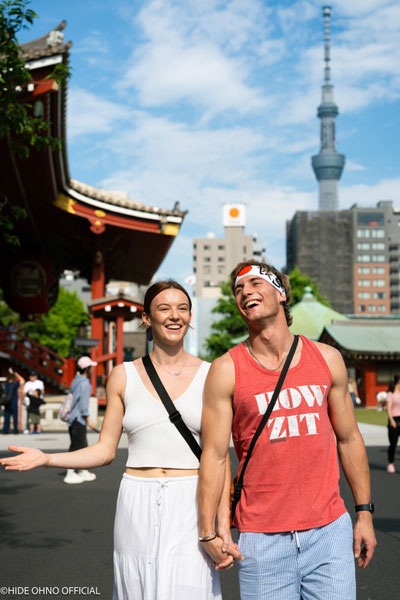 Happy couple walking in Asakusa with Tokyo Skytree and temple gate in the background — capturing the joy of Tokyo travel