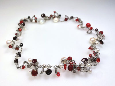 Flexible Kette mit roten Steinen und weißen Perlen