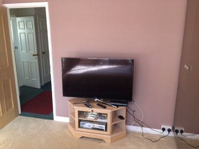 TV on cabinet on the floor with sky and blu-ray dvd and a mess of wires and cables.