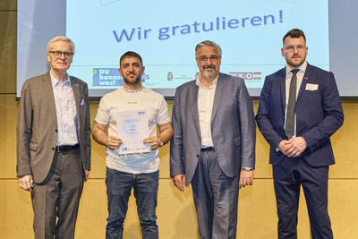 Stolzer Absolvent mit Urkunde in der Hand