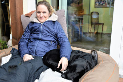 Nina Hoffmann mit Hund Emily im Rollstuhl im Winter auf der Terrasse