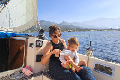Mère et sa fille dans le cockpit du voilier en navigation