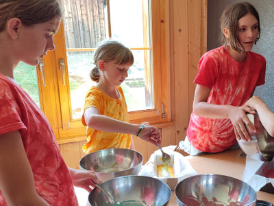 Teilnehmerinnen beim backen - gemeinsam probieren wir in diesem Ferienlager leckere Rezepte aus