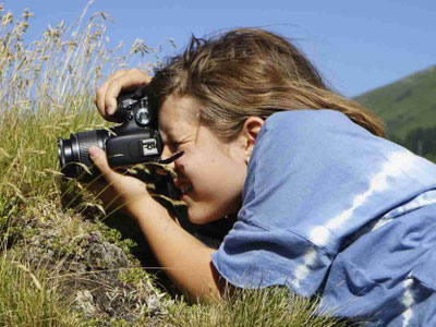 Teilnehmerin mit Kamera in der Natur - in diesem Ferienlager stehen Videoprojekte im Vordergrund