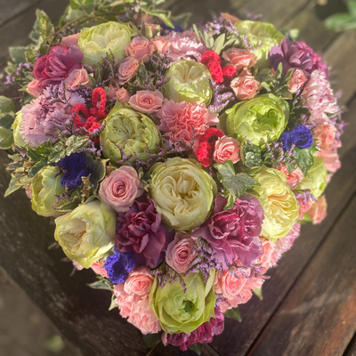 Cette photo représente un cadre blanc dans lequel sont disposées des fleurs roses