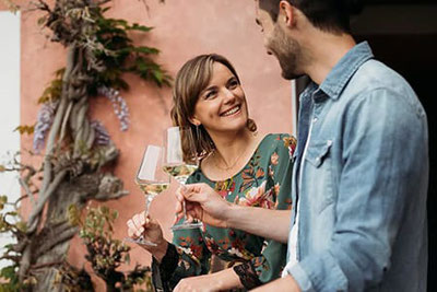 Ein junges Paar genießt Weißwein beim sommerlichen Weinevent Wine Summer & Stadtl Summer in Klausen, Südtirol