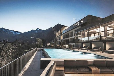 SomVita Suites Dorf Tirol bei Nacht mit Infinity-Pool, modernem Wellnessbereich und traumhaftem Panoramablick auf die Südtiroler Bergwelt.