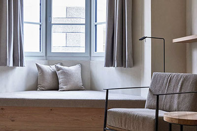 Vista su una suite arredata in modo essenziale con bovindo all'Hotel fink di Bressanone in Alto Adige