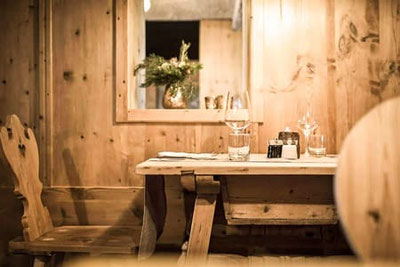 Gemütliches Fine-Dining-Ambiente im Frieda’s Restaurant im Hotel Belvedere in Jenesien – helle Zirbenstube mit Holztischen, stilvollen Details und warmem Licht.
