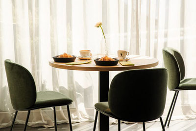 Angolo colazione con croissant e caffè al Café Bistro Emmi a Scena, nei pressi di Merano: un ambiente moderno inondato dalla luce del giorno.