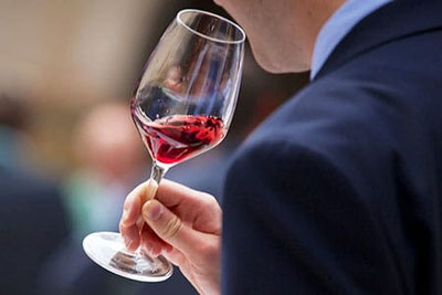 Persona degusta un bicchiere di Pinot Nero durante le Giornate Altoatesine del Pinot Nero in Alto Adige, con focus su colore e aromi nel calice